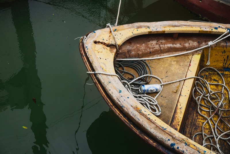 a rusty old boat on the river tied with rope and a beer inside it the mooring tai o, beer inside a rusty old boat_ 4k
