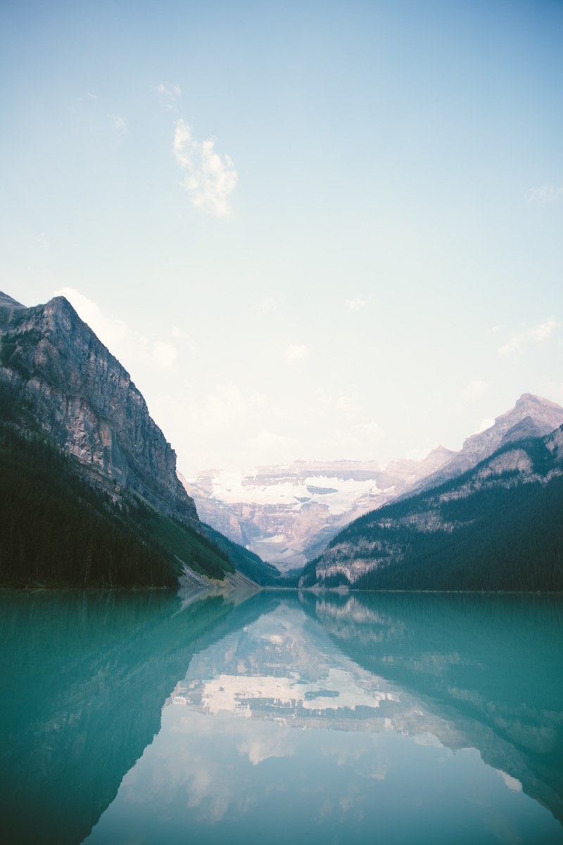 surrounding hills and trees reflected in the water of lake louise, lake louise landscape 4k