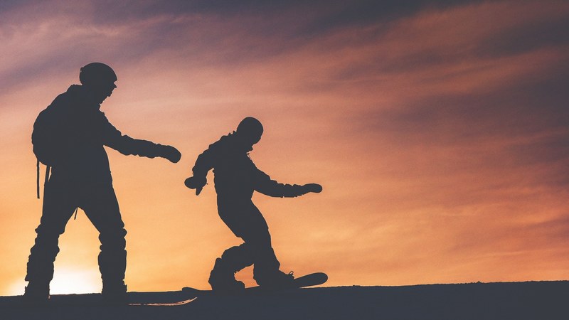 silhouette of two snowboarders in zell am see attempting to ride during sunset, snowboarders during sunset 4k