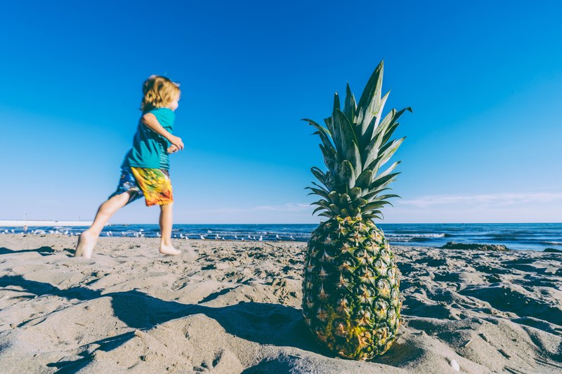 a body running in front of a pineapple on at port stanley beach, running at port stanley 4k