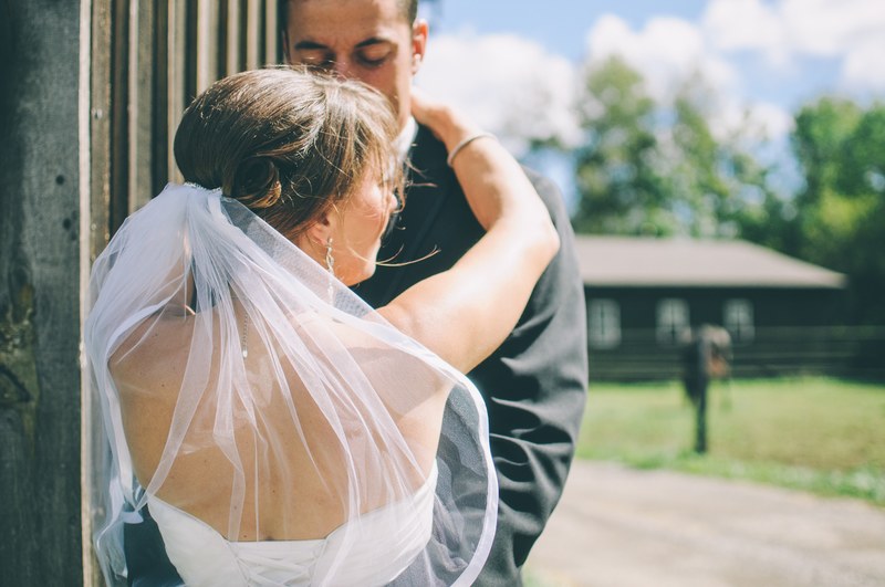 a bride and groom embrace outdoors on a sunny day in london, wedding couple at old building 4k