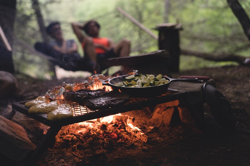 meat vegetables and other food grill over campfire while relaxing in the woods, cooking in nature 4k