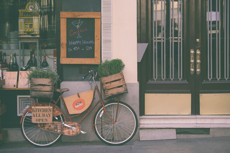 a vintage red bicycle parked in front of a shop, _bar facade with a bicycle 4k