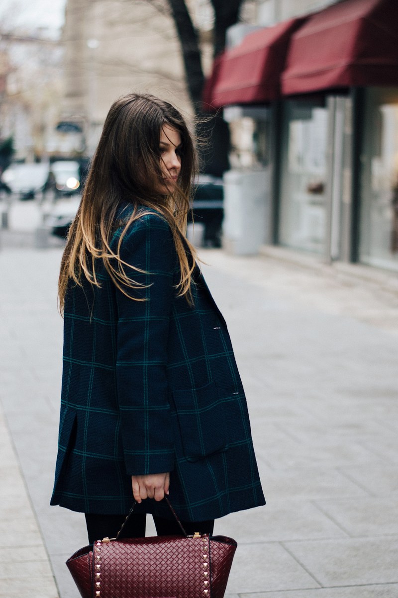 a woman wearing a plaid jacket and red handbag on the street in bucharest, lost in the city 4k