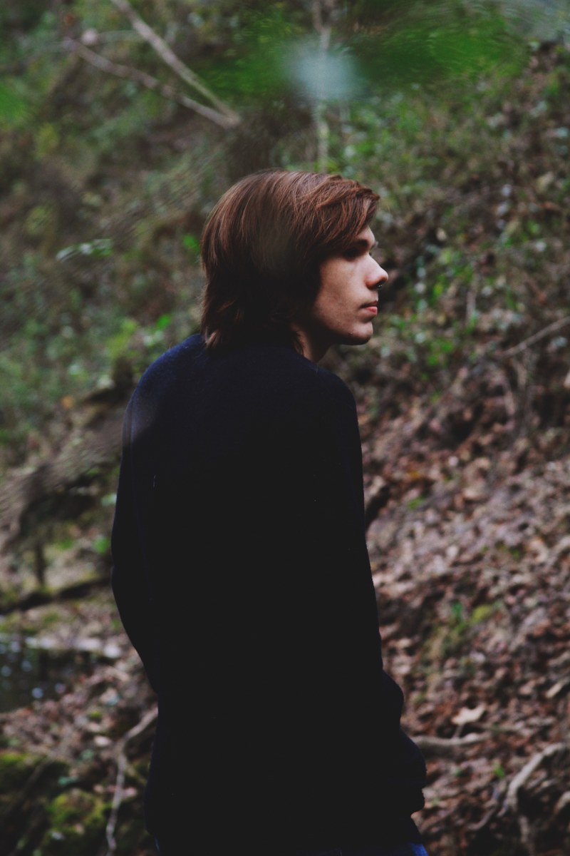 young man with long hair walking alone in the woods, lonely forest walk 4k
