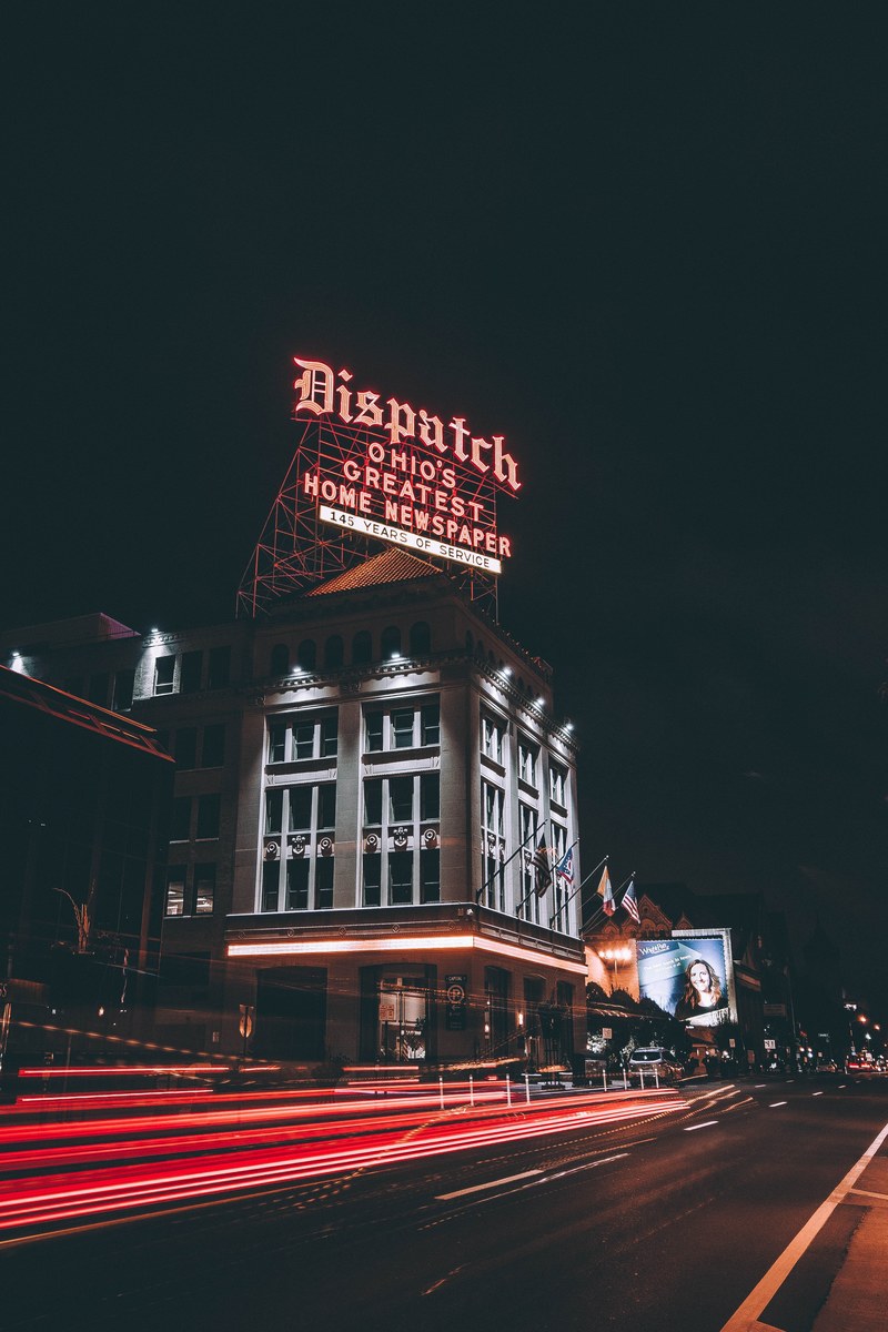 a building in columbus with a red light trail passing nearby on an urban street, columbus city light trails 4k