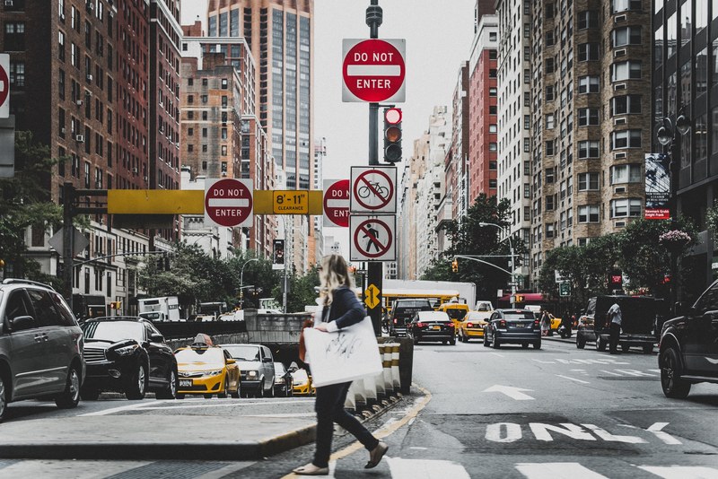 a woman walking across a busy new york city street with do not enter signs, crosswalk 4k