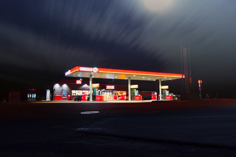 an overexposed gas station illuminated with a blurry night sky above, illuminated patrol station at night 4k