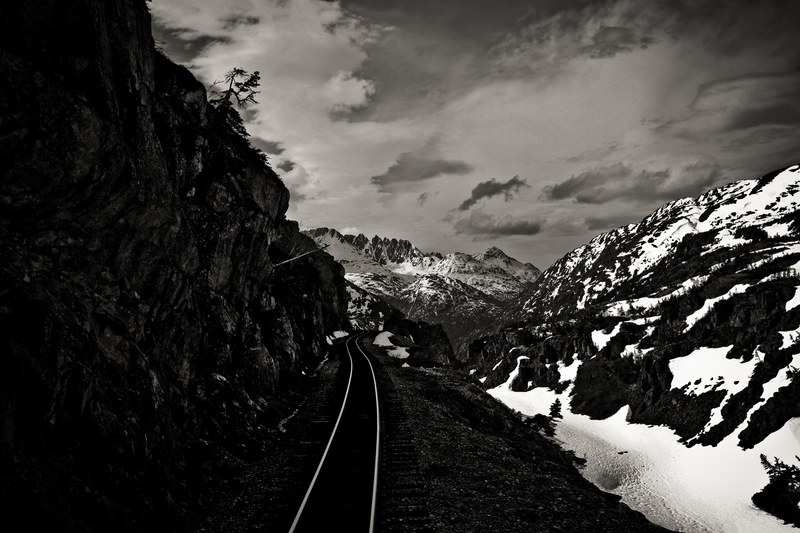 railroad track lines the side of a mountain in the snow, railroad on a mountain 4k