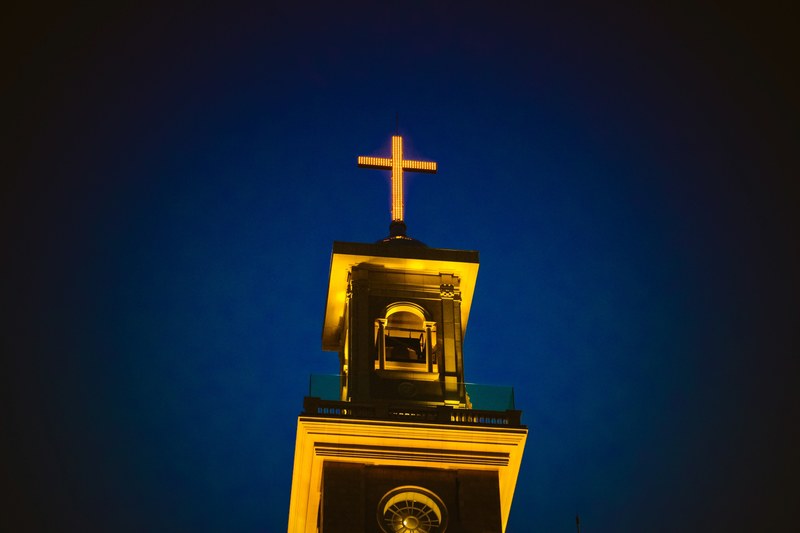 a lighted church steeple and cross against the dark blue night sky in beirut, _light in the night 4k