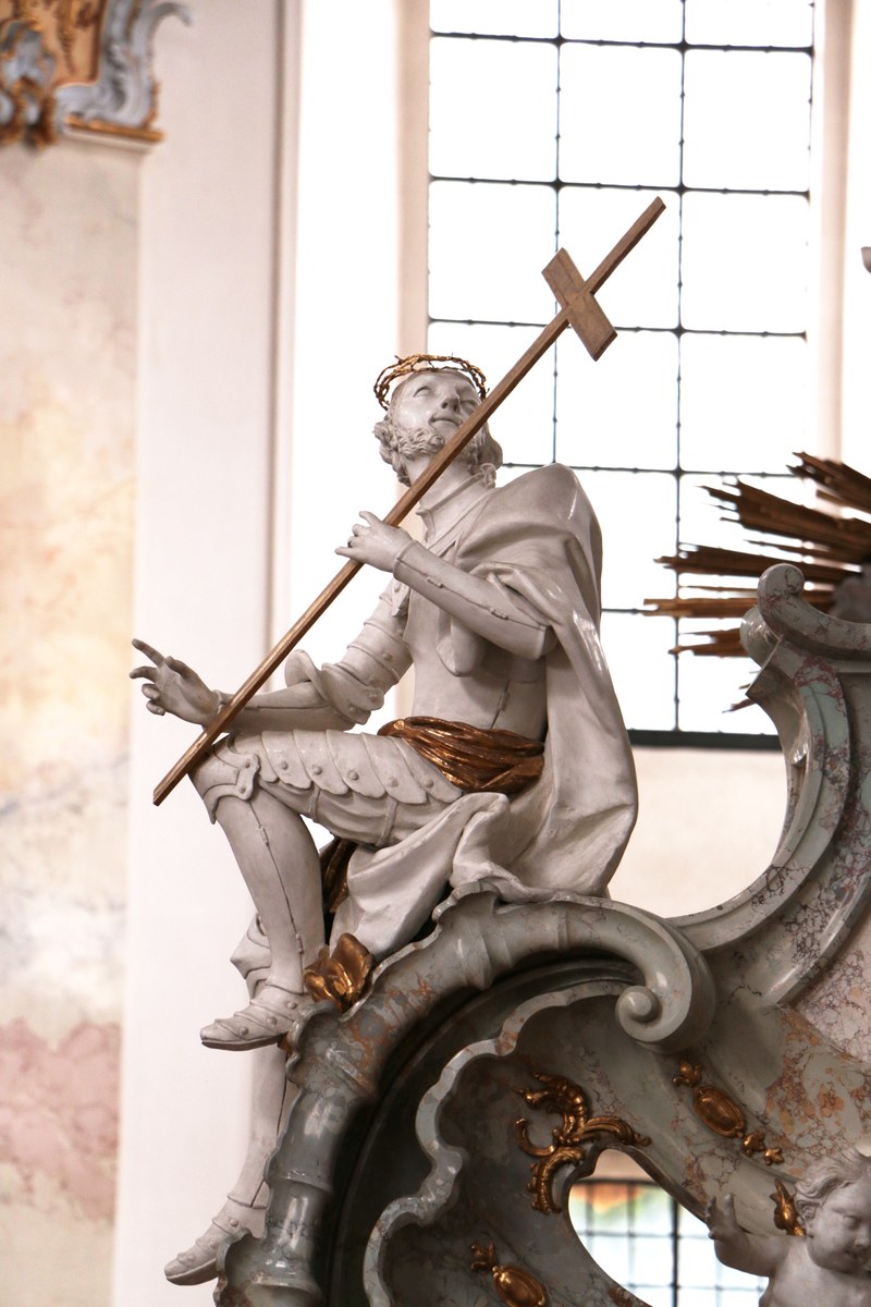 a sculpture of a warrior carrying a cross sitting on the corner of a mantelpiece while looking up, warrior religious sculpture 4k