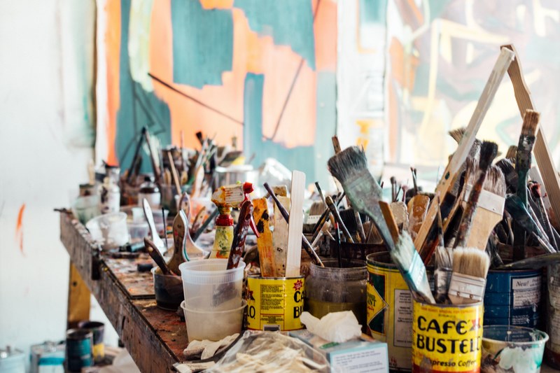 assorted messy paint supplies on wooden table in art studio marshall arts gallery, art supplies clutter 4k