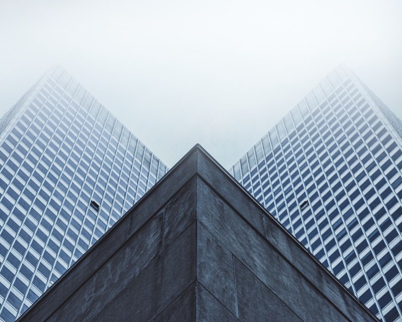 two high rise wings towering above the roof of a lower building in montreal, montreal buildings 4k