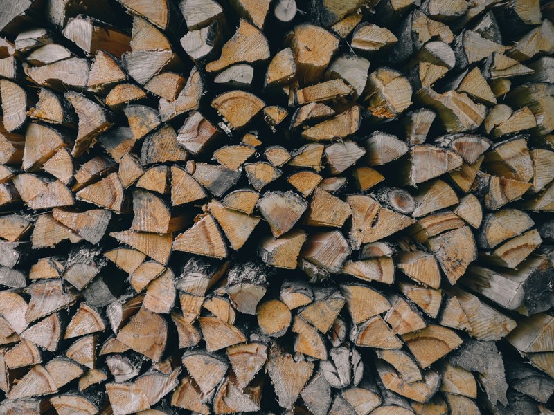 a large stack of firewood cut into wedge shaped pieces, stack of chopped wood 4k