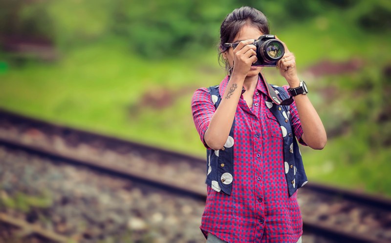woman wearing pink shirt blue vest and watch while taking pictures with a camera, in love with my camera 4k