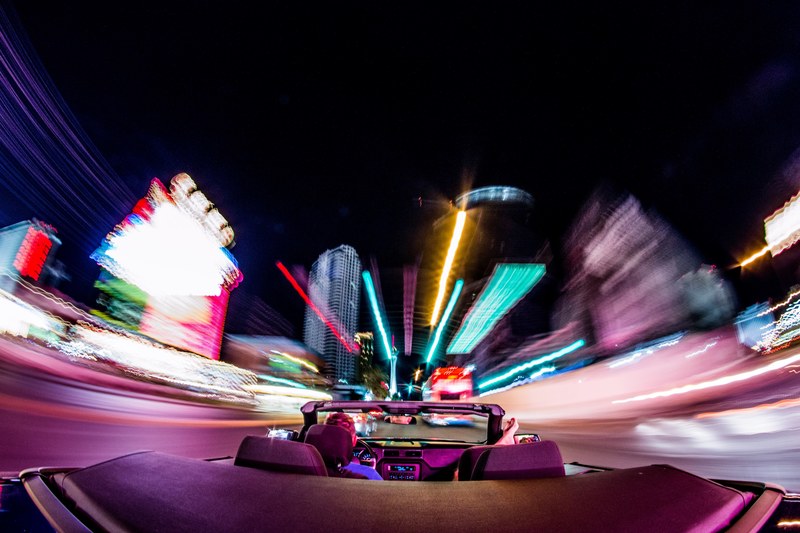 a rear pov of a convertible driving through the las vegas strip with light trails, _driving in las vegas at night 4k