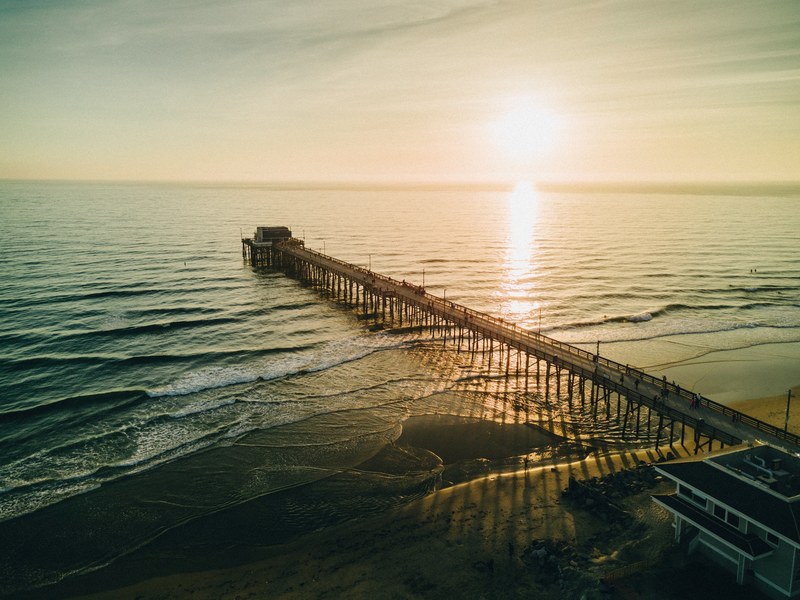 view of the long pier at the newport beach at sunset, newport pier sunset 4k
