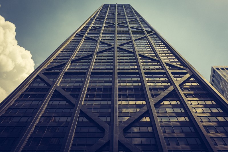 looking up at a tall dark skyscraper with windows and diagonal and vertical lines, tall dark scyscraper building 4k