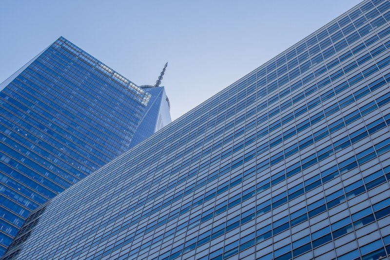 a low angle shot of a skyscraper with a spire rising above other high rises, skyscraper spire 4k