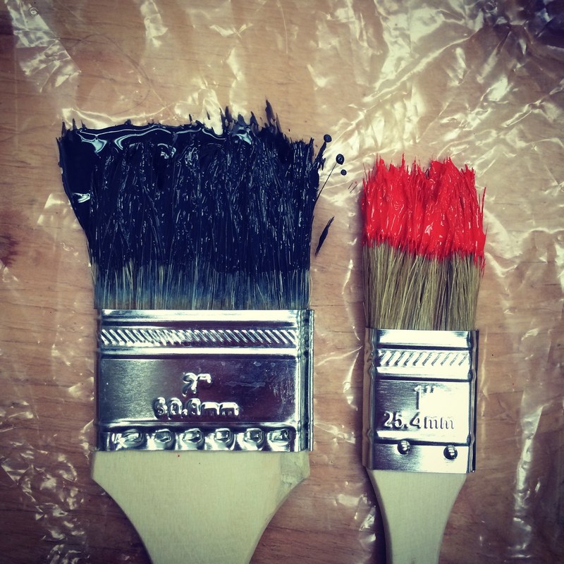 two paintbrushes of varying size dipped in paint lying on table california college of the arts, big and small paintbrush 4k