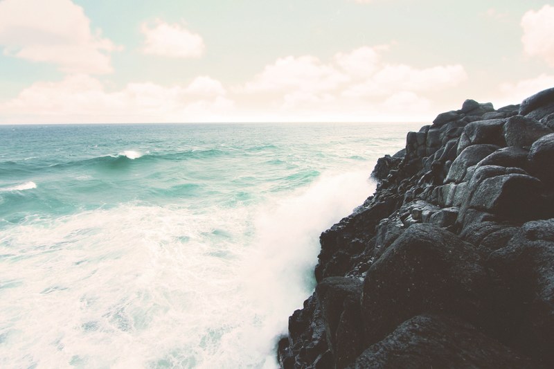 cresting waves and white surf crashing against the rocks on the shore at fingal head, waves crashing against the shore 4k