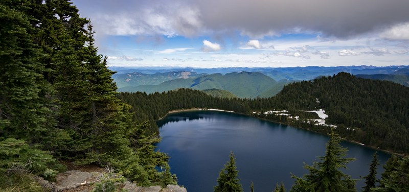 a smooth dark lake among green hills, dark summit lake 4k