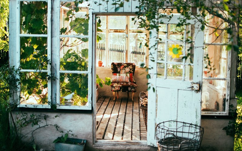 exquisite greenhouse surrounded by sunflowers with colorful folding chair inside, greenhouse with colorful folding chair 4k