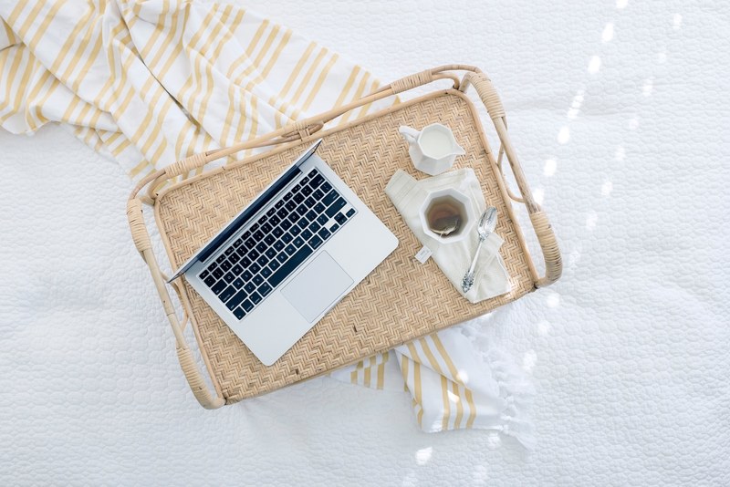 a laptop and a cup of tea with milk on a wicker tray, laptop on a wicker tray 4k