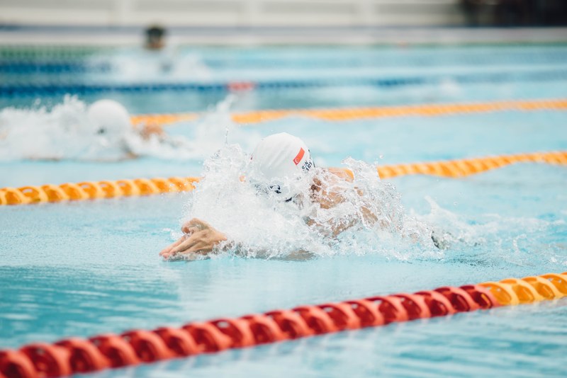 a person lane swimming in a pool wearing a cap, lane swimmer 4k