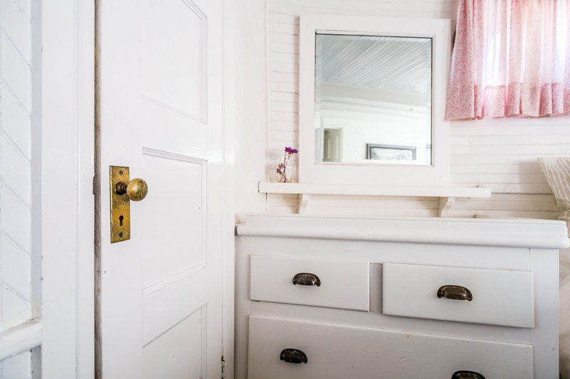 neat bathroom interior with white wooden door drawers mirror flowers and pink curtains, floating on 4k