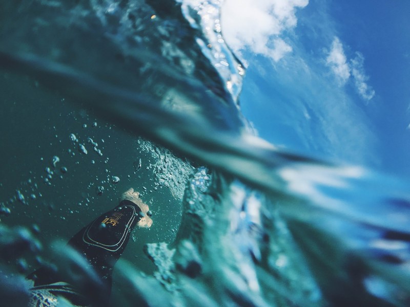 first person view of a swimmer swimming through ocean in swimsuit at narrow neck beach, swimmer splashing water 4k