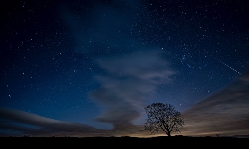 a night time background featuring a blue sky with gusty dark clouds in malham cove, malham cove astrophotography 4k