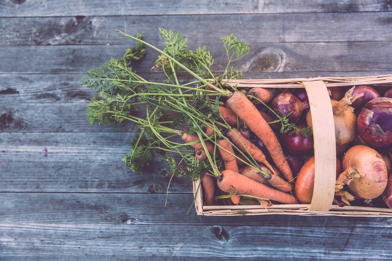 a basket of red onions carrots and white onions on a table in erlangen, basket of vegetables 4k