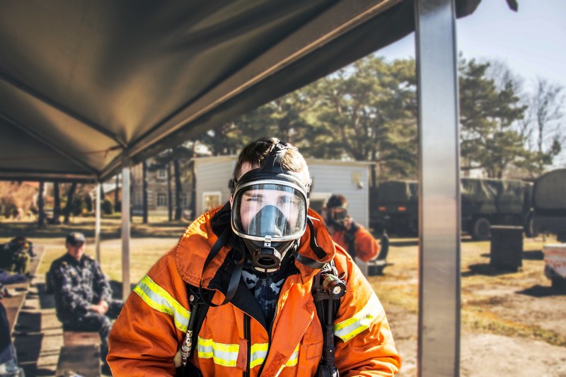 a person wearing a firefighter costume and safety mask on an army base, firefight in army 4k
