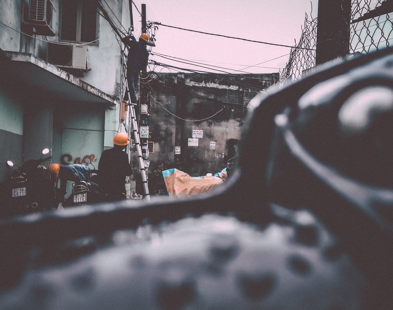 construction workers working near a building facade with a ladder, street 4k