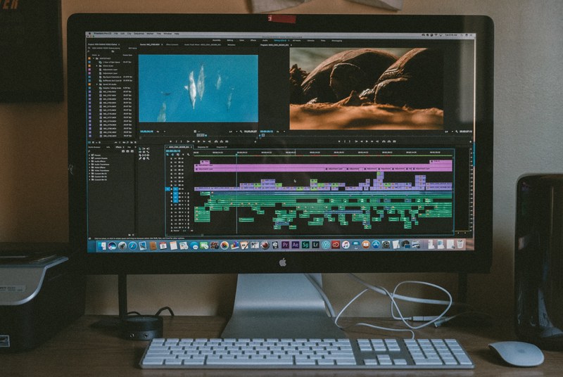apple desktop computer with editing software on the screen with keyboard and printer, timeline tuesday 4k