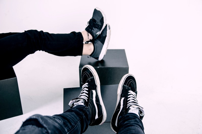 two people in sneakers sitting with their legs on black cubes, sneakers on black cubes 4k