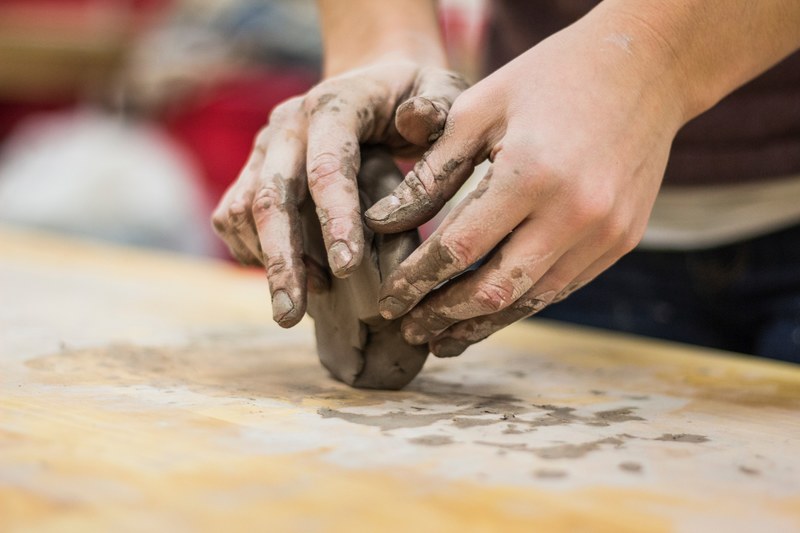 a clay stained hand of a potter engaging in a craft work of pottery or molding, pottery and craft 4k