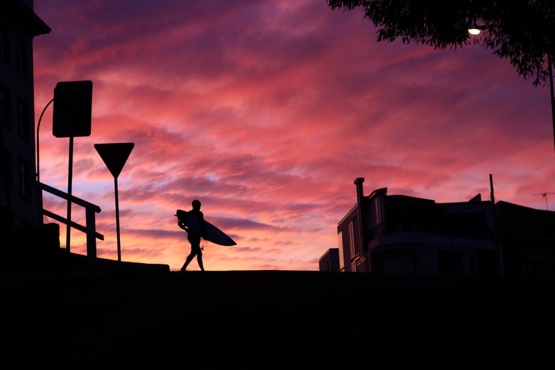 surfer silhouette crossing the street at bondi beach after sunset, sunset silhouttes bondi beach 4k