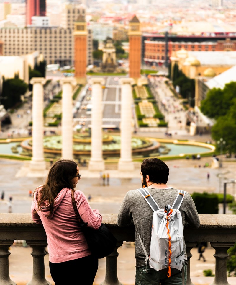 a man and a woman talk on a balcony in barcelona overlooking the city, on a balcony in barcelona 4k