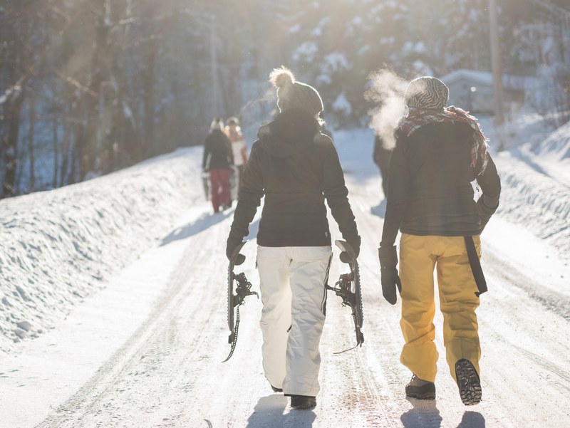 a few snowboarders walking a winter path with visible breath, snowboarders breath on a cold day 4k