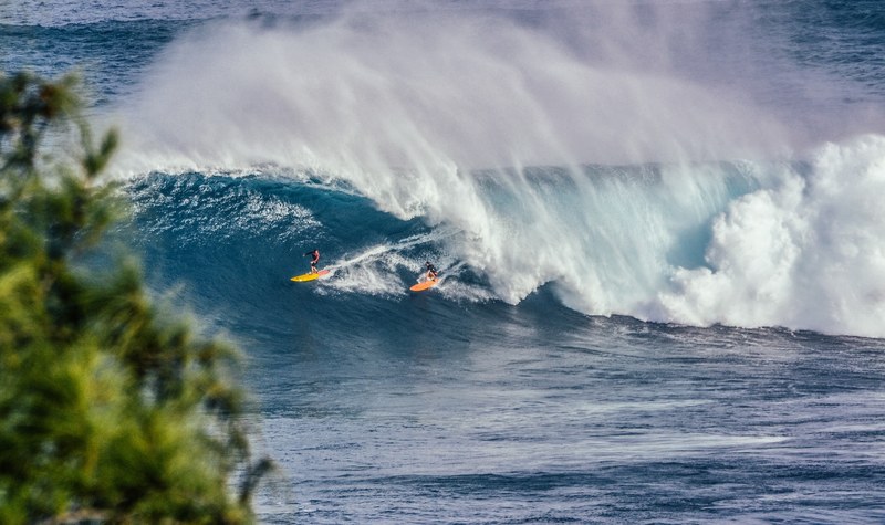 two surfers in the water as the waves break at jaws, two surfers in between the waves 4k