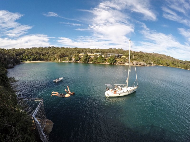 a person diving in front of a sailboat, _diving near sailboat 4k