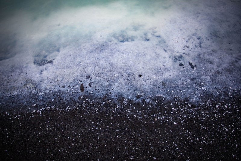 ocean foam washing on the black sand beach in iceland, ocean foam washing on beach 4k