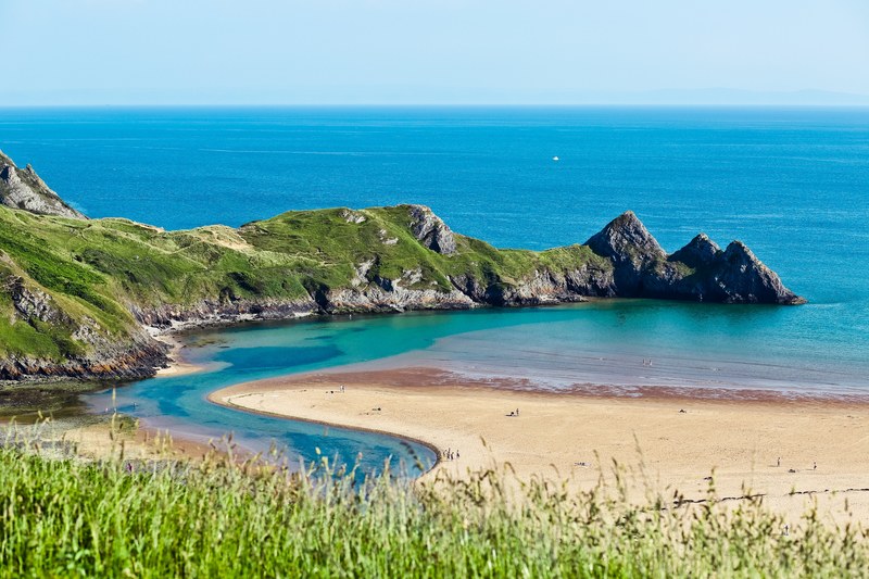 view on an ocean bay and a lagoon from a grass field in wales, ocean bay view in wales 4k