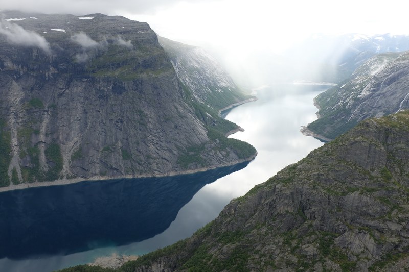 calm valley river sits between lush mountains in trolltunga, view of the valley 4k