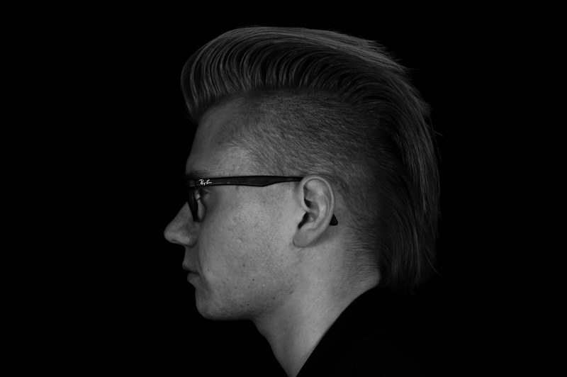 black and white shot of young man with glasses and mohican hair cut, monochrome mohican hair 4k