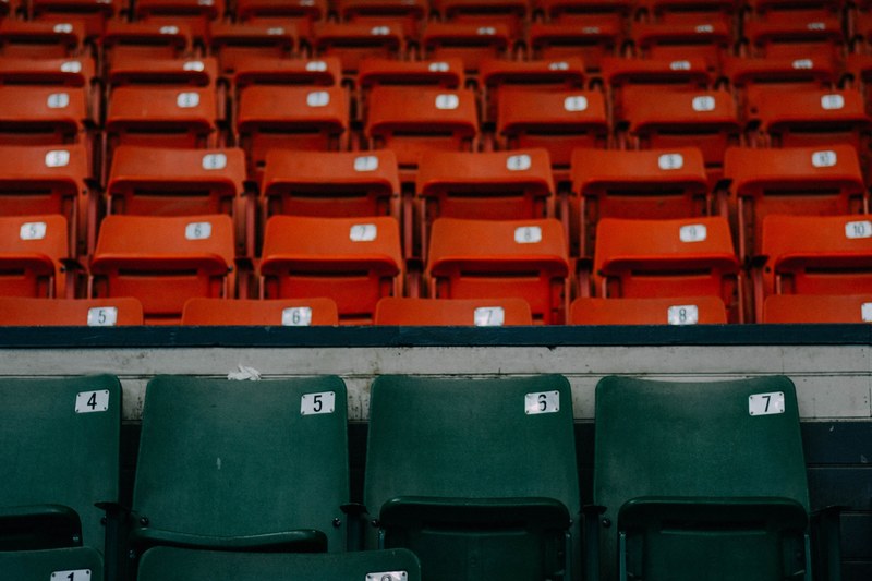 several rows of numbered seats and a first row of green numbered seats on a springfield baseball stadium bleacher, chairs in stadium 4k