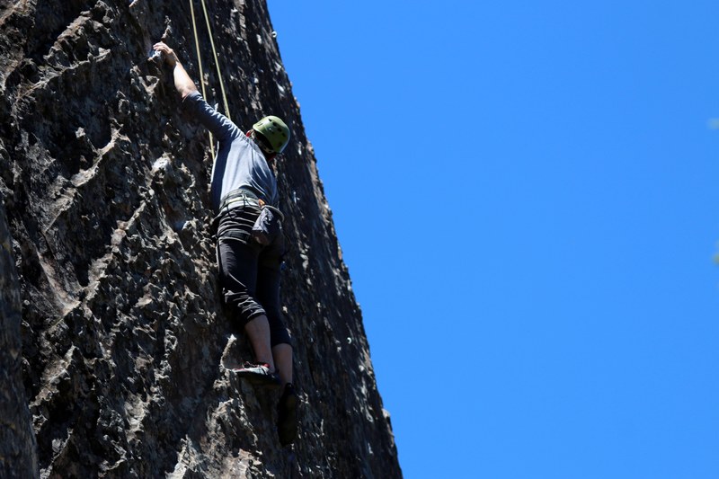 a man rock climbing outdoors on a mountain on a nice day with blue skies, man rock climbing 4k