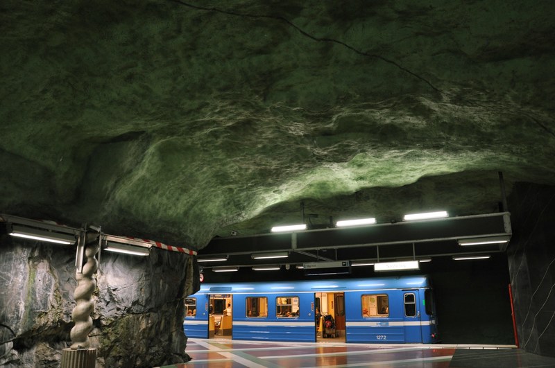 a blue subway train under a rocky underground, underground subway 4k